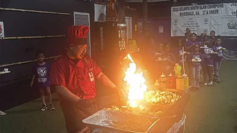 Hibachi chef performing a fire show during a private event